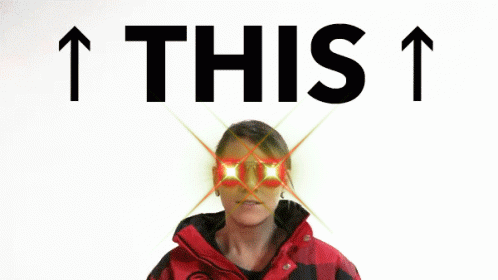 Woman In Red And Black Jacket Pointing Up Behind The Words This GIF