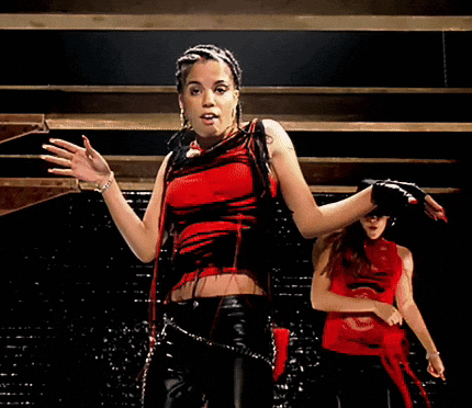 A Woman In A Red And Black Top Is Dancing GIF