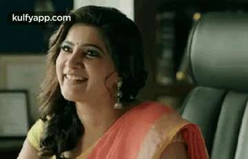 A Woman In A Red And Yellow Saree Is Smiling While Sitting In A Car . GIF