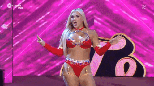 A Woman In A Red Bikini Is Standing On A Stage With Her Arms Outstretched . GIF