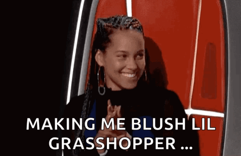 A Woman In A Red Chair Is Smiling And Making A Funny Face . GIF