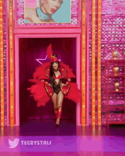 Woman In Red Costume Walking Through Doorway With Twitter Logo GIF