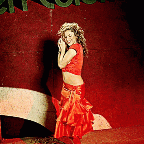 A Woman In A Red Crop Top And Red Skirt Stands In Front Of A Sign That Says ' A ' On It GIF