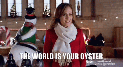 A Woman In A Red Dress And Scarf Is Standing In Front Of A Christmas Decoration And A Snowman . GIF