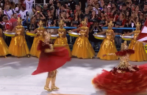 A Woman In A Red Dress Is Dancing In Front Of A Crowd Wearing A Staff Shirt GIF