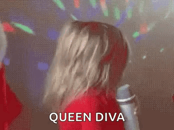 A Woman In A Red Dress Is Dancing In Front Of A Microphone And The Words Queen Diva Are Written On The Screen . GIF