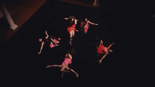 A Woman In A Red Dress Is Dancing In Front Of A Red Cloth GIF