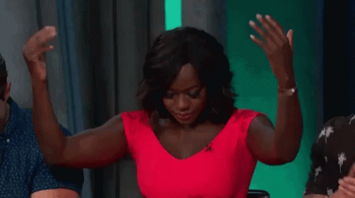 A Woman In A Red Dress Is Dancing With Her Arms In The Air . GIF