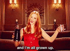 A Woman In A Red Dress Is Holding A Bottle Of Alcohol And A Glass Of Water .. GIF