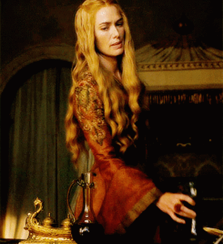 A Woman In A Red Dress Is Holding A Bottle Of Wine GIF