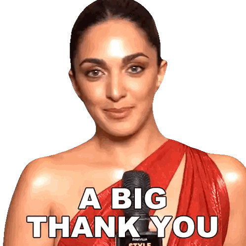 a woman in a red dress is holding a microphone and saying a big thank you