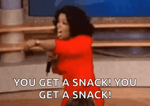 a woman in a red dress is holding a microphone and saying you get a snack you get a snack .