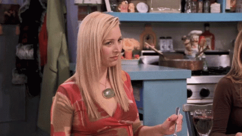 A Woman In A Red Dress Is Holding A Spoon In Her Hand GIF