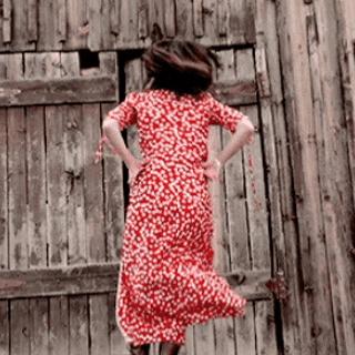 a woman in a red dress is jumping in the air