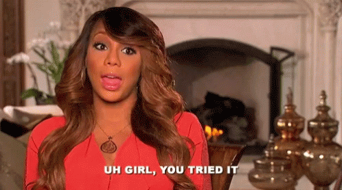 A Woman In A Red Dress Is Sitting In Front Of A Fireplace And Talking . GIF