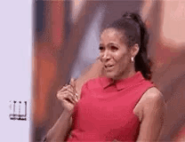 A Woman In A Red Dress Is Sitting On A Couch And Crying . GIF
