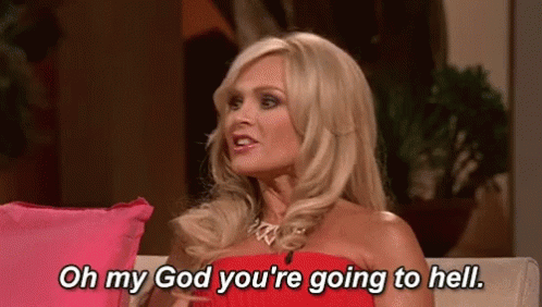 A Woman In A Red Dress Is Sitting On A Couch And Talking To Someone . GIF