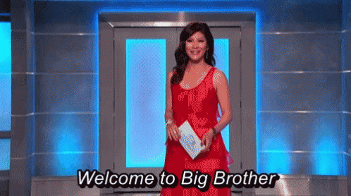 a woman in a red dress is standing in front of a blue door and says welcome to big brother