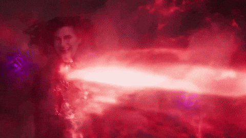 A Woman In A Red Dress Is Surrounded By Red Smoke And A Red Light . GIF