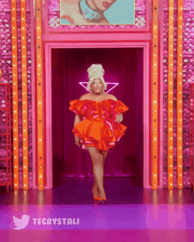 Woman In Red Dress Walking Down Runway With Twitter Logo GIF