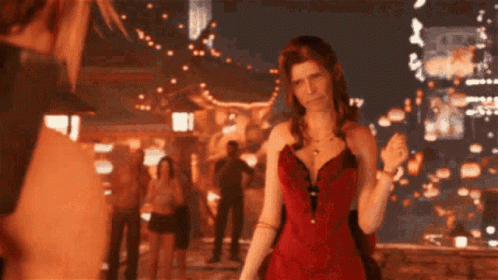 A Woman In A Red Dress Stands In Front Of A Crowd Of People GIF