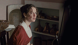 A Woman In A Red Dress Stands In Front Of A Shelf GIF