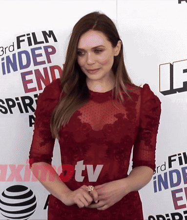 A Woman In A Red Dress Stands In Front Of A Sign That Says 3Rd Film Independent Spirit GIF