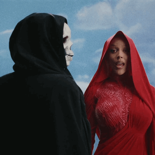 A Woman In A Red Dress Stands Next To A Grim Reaper In A Black Cape GIF