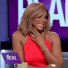 A Woman In A Red Dress With A Purple Sign That Says Real GIF