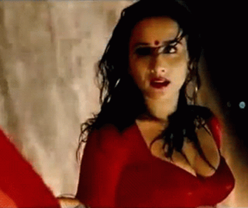 A Woman In A Red Dress With A Red Dot On Her Forehead . GIF