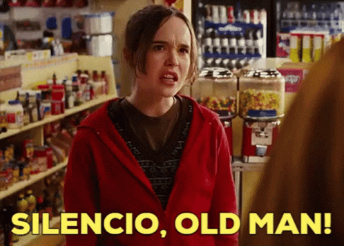 A Woman In A Red Hoodie Says Silencio Old Man In A Store GIF