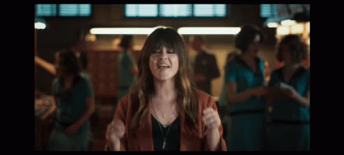 A Woman In A Red Jacket Is Making Funny Faces GIF