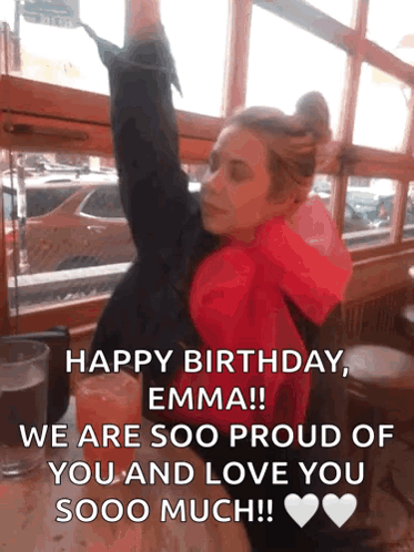 A Woman In A Red Jacket Is Sitting At A Table With Her Arms In The Air And A Birthday Message GIF