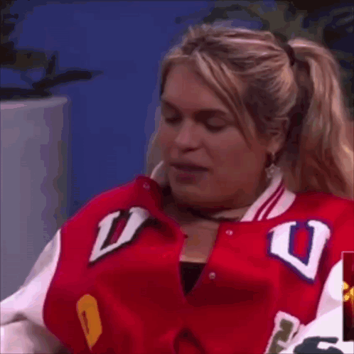 A Woman In A Red Jacket With The Letter U On It GIF