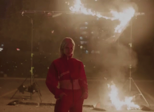 A Woman In A Red Jacket With The Word Adidas On It GIF