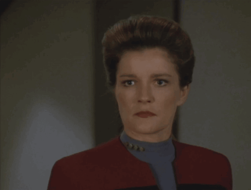 A Woman In A Red Jacket With The Word Coward Written On It GIF
