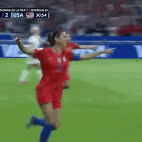 A Woman In A Red Jersey Is Running On A Soccer Field During A Game Against The Usa GIF