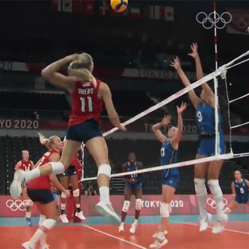 A Woman In A Red Jersey With The Number 11 Jumps To Block A Volleyball GIF