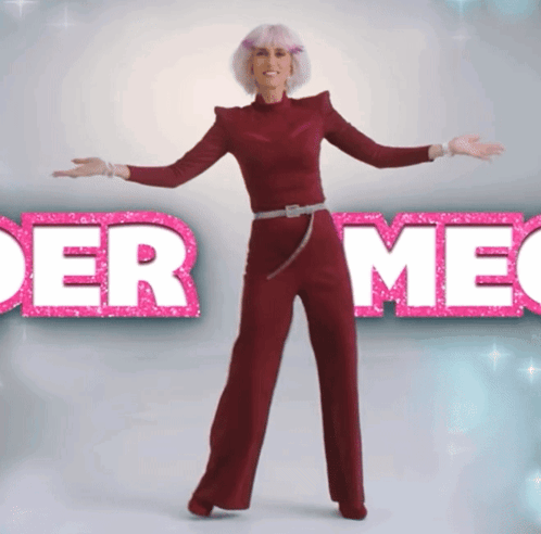 A Woman In A Red Jumpsuit Stands In Front Of A Sign That Says " Der Meg " GIF