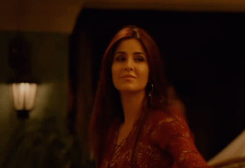 A Woman In A Red Lace Top Is Smiling GIF