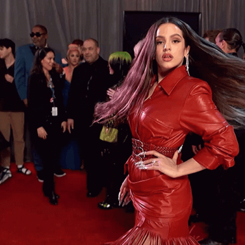 a woman in a red leather dress is posing for a picture