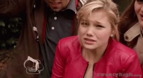A Woman In A Red Leather Jacket Is Standing Next To A Group Of People . GIF