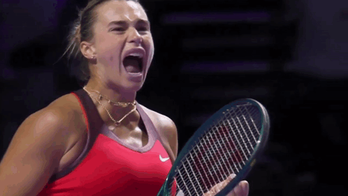 A Woman In A Red Nike Shirt Is Holding A Tennis Racket GIF