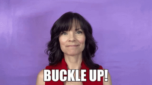 A Woman In A Red Shirt Is Holding A Red Stick And Says Buckle Up ! GIF