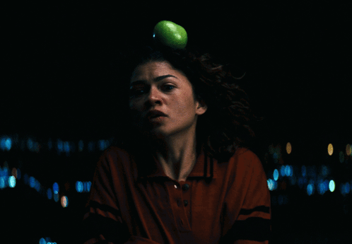 a woman in a red shirt is looking at the camera