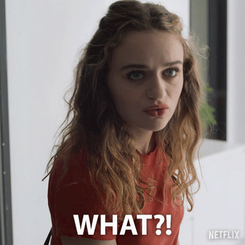 A Woman In A Red Shirt Is Making A Funny Face With The Words What Written Below Her GIF