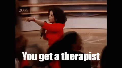 A Woman In A Red Shirt Is Pointing At A Crowd With The Words You Get A Therapist Written Below Her GIF