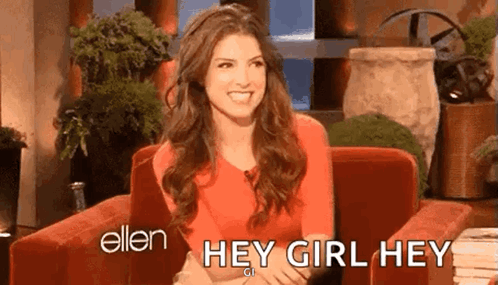 A Woman In A Red Shirt Is Sitting In A Chair And Smiling While Talking To Ellen Degeneres . GIF