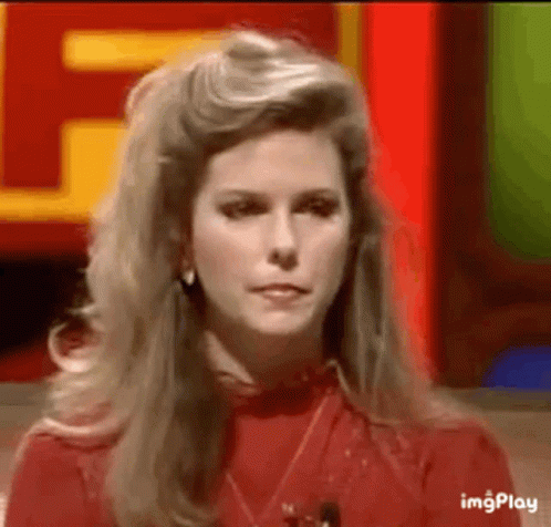 A Woman In A Red Shirt Is Sitting In Front Of A Red Sign . GIF