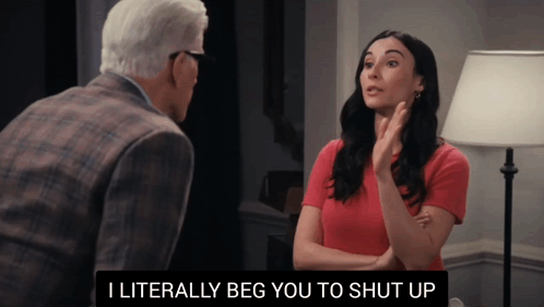 A Woman In A Red Shirt Is Talking To An Older Man In A Suit GIF